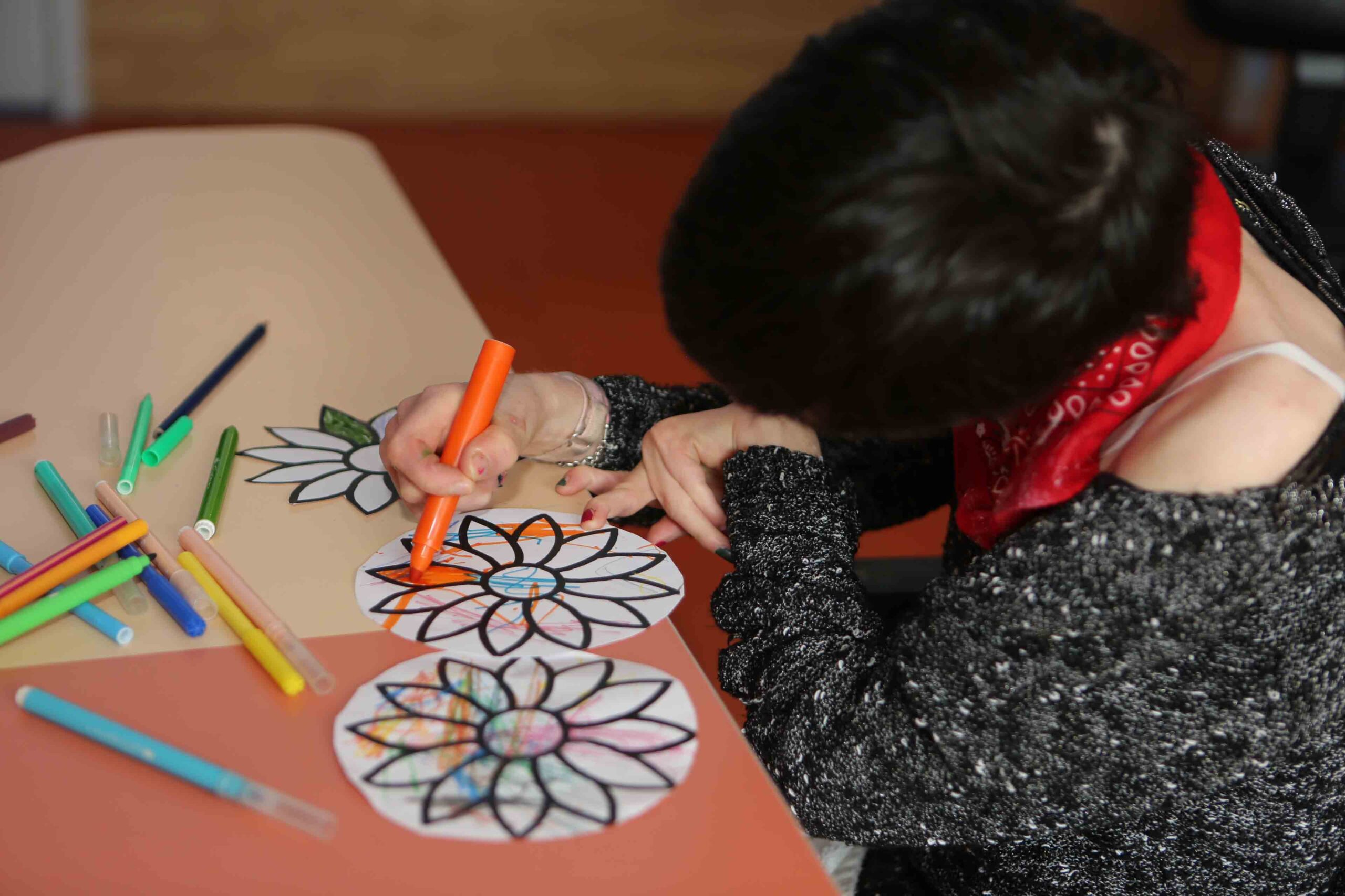 Un enfant en atelier coloriage, on ne voit le visage de l'enfant